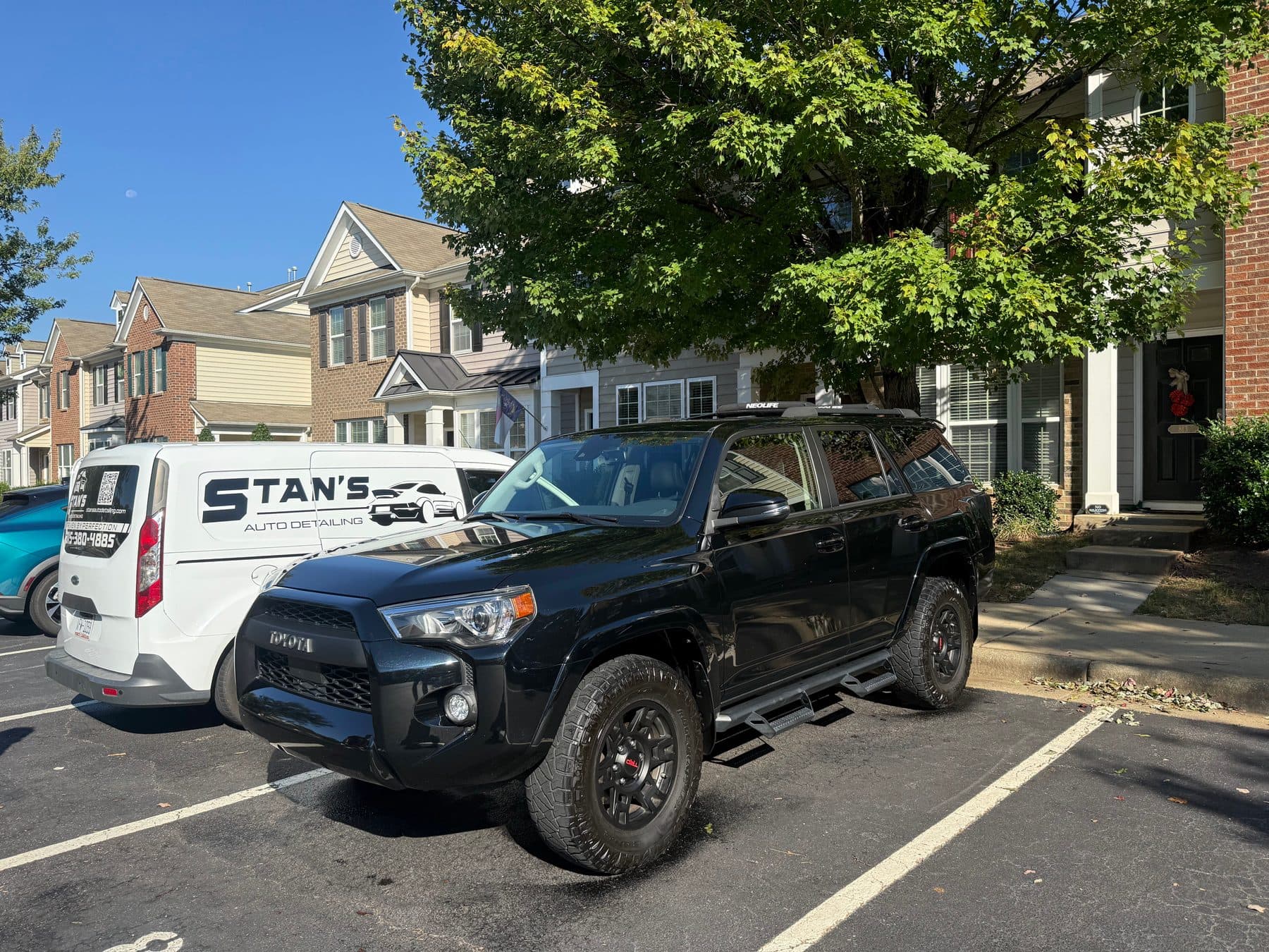 Black Toyota 4Runner TRD detailed on site with the Stan's van behind it