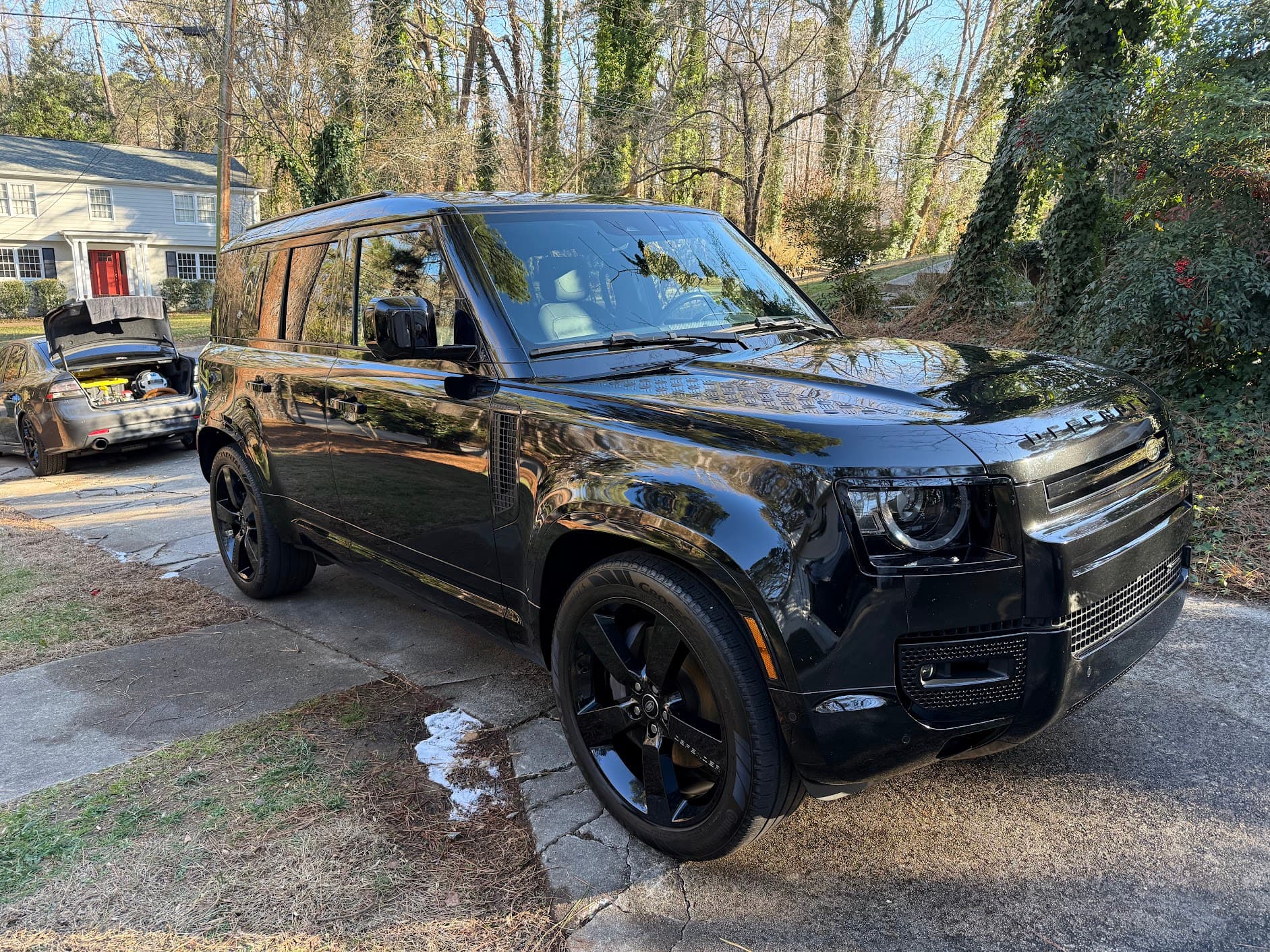 Black Land Rover Defender with gloss black wheels after a full detail