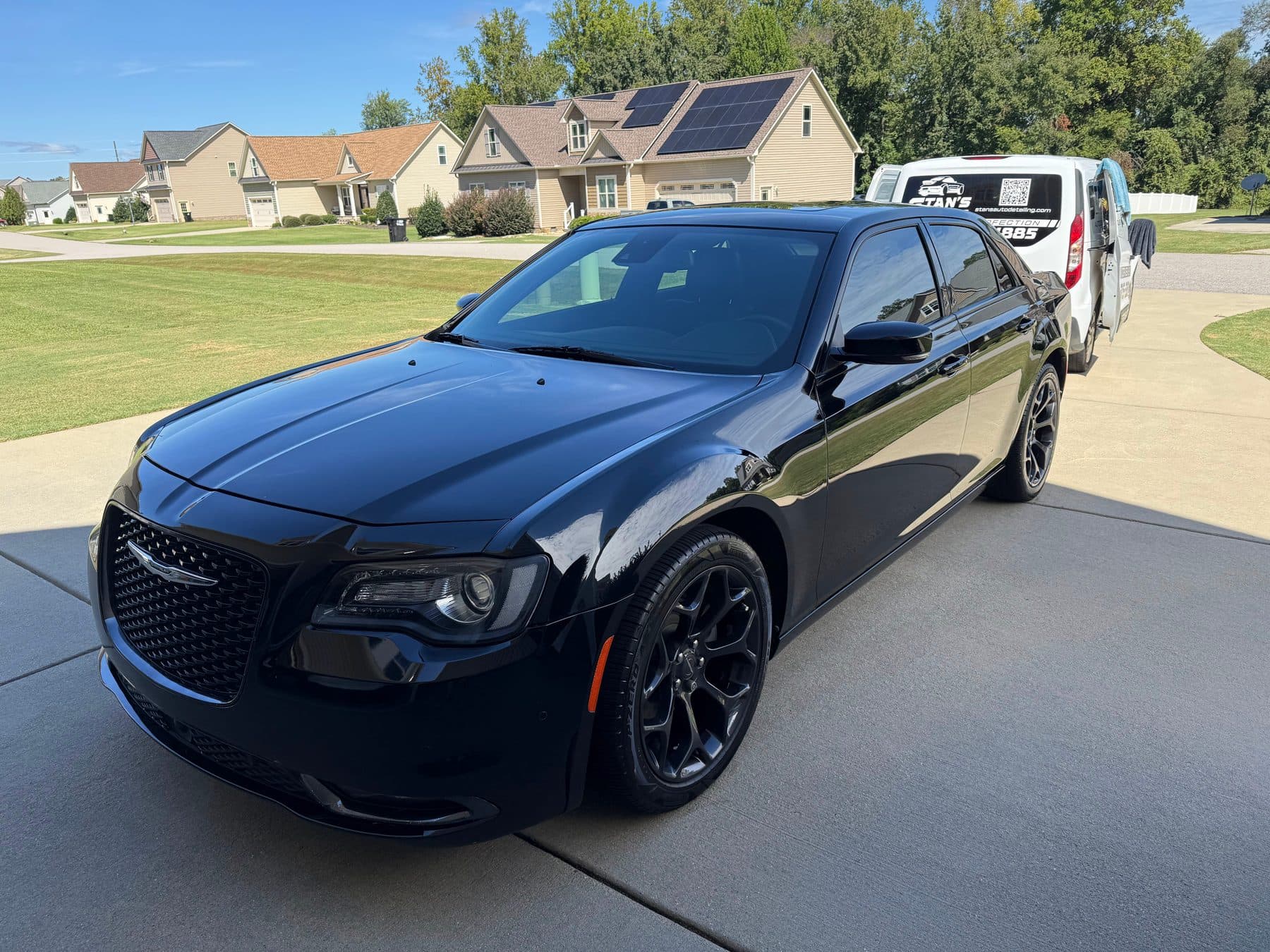 Blacked-out Chrysler 300S detailed in a client's driveway