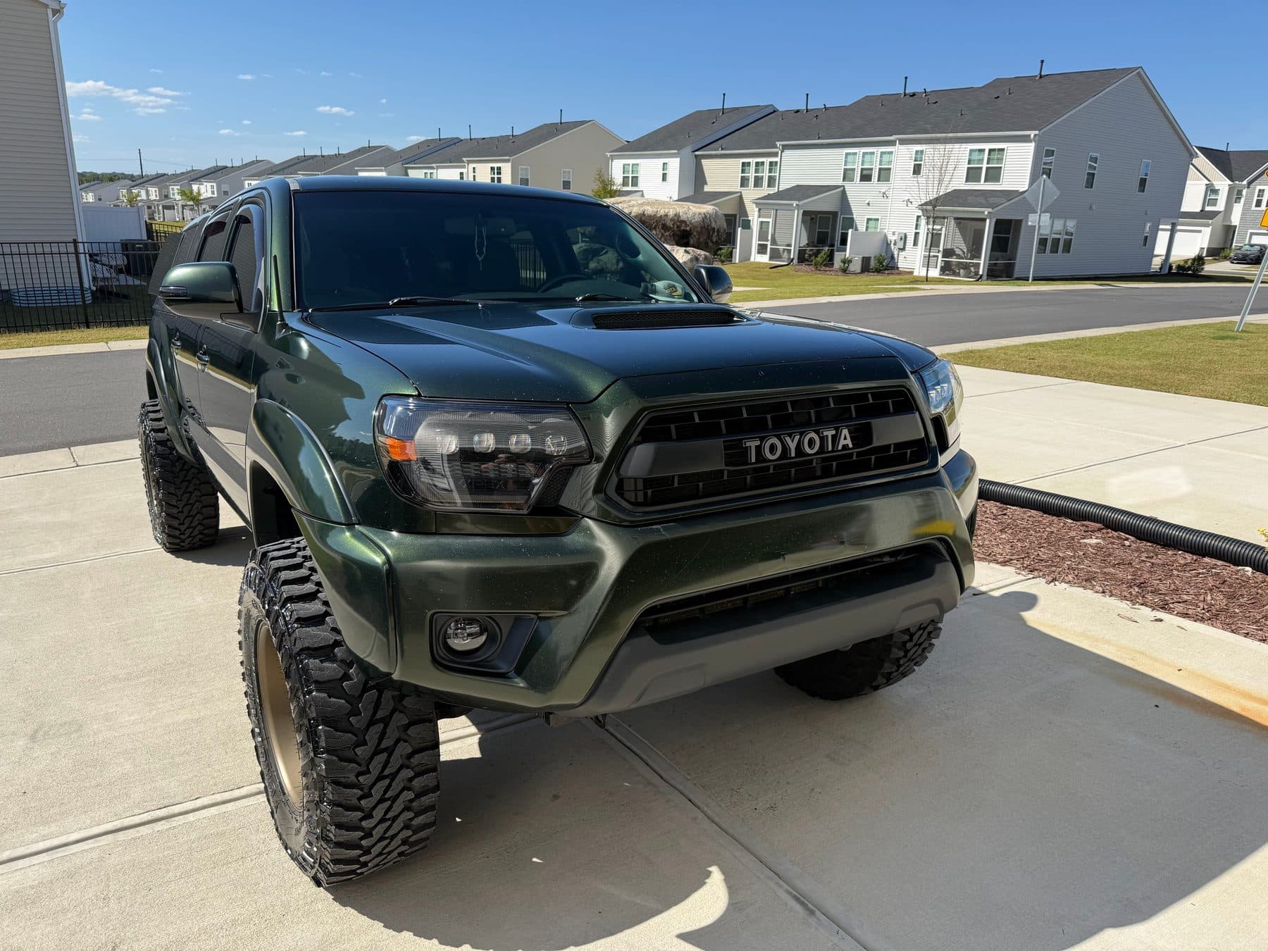 Lifted army green Toyota Tacoma TRD with fresh paint gloss
