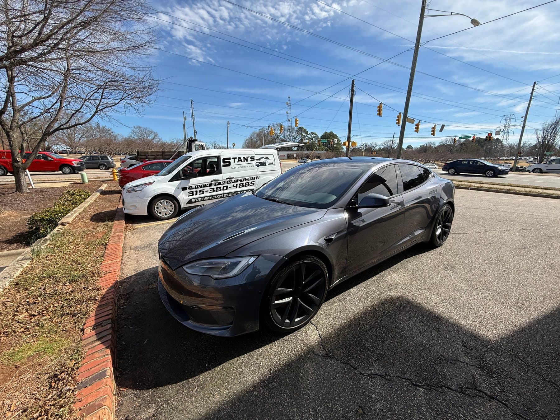 Tesla Model S Plaid detailed on site with the Stan's van behind it